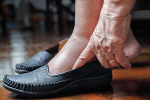 Elderly woman putting on her shoes