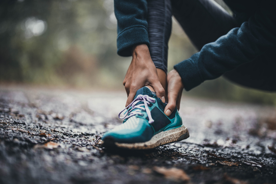 Close up of unrecognizable athletic woman feeling pain in her ankle at the park.
